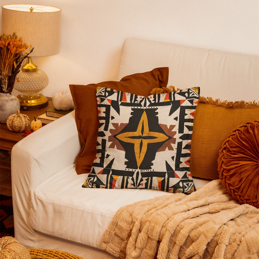 Decorative throw pillow on white couch in cozy fall-themed living room with warm accents