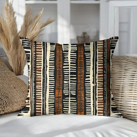 Boho mud cloth throw pillow with brown, black, and cream tribal pattern on a neutral sofa