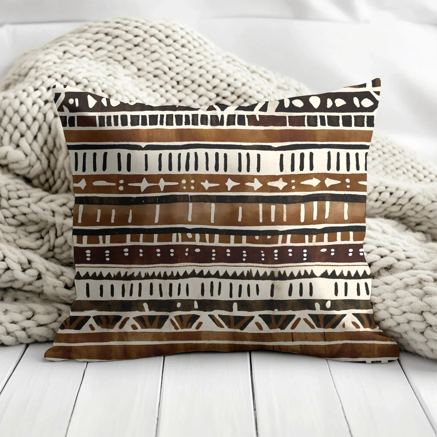 Boho mud cloth throw pillow with brown tribal pattern on chunky knit blanket