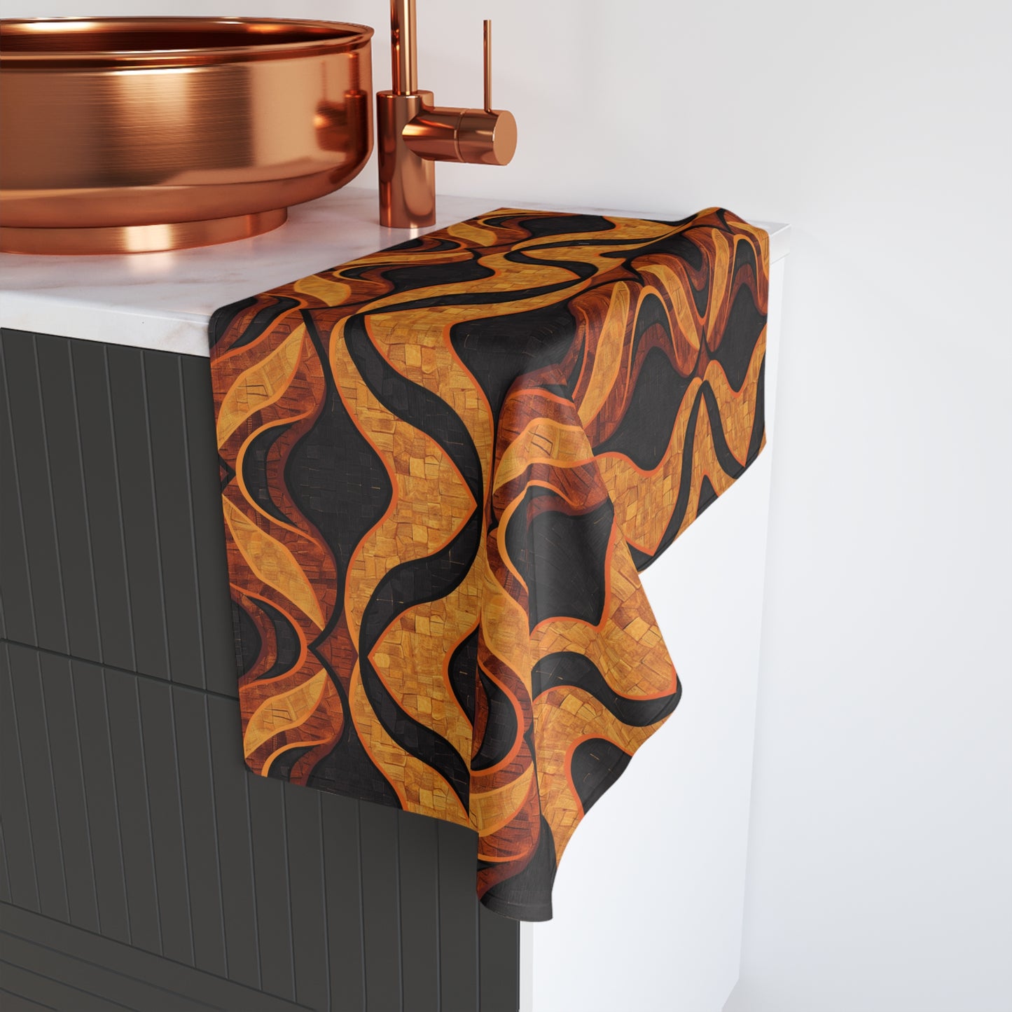 Mudcloth patterned towel draped over a bathroom cabinet with copper fixtures.
