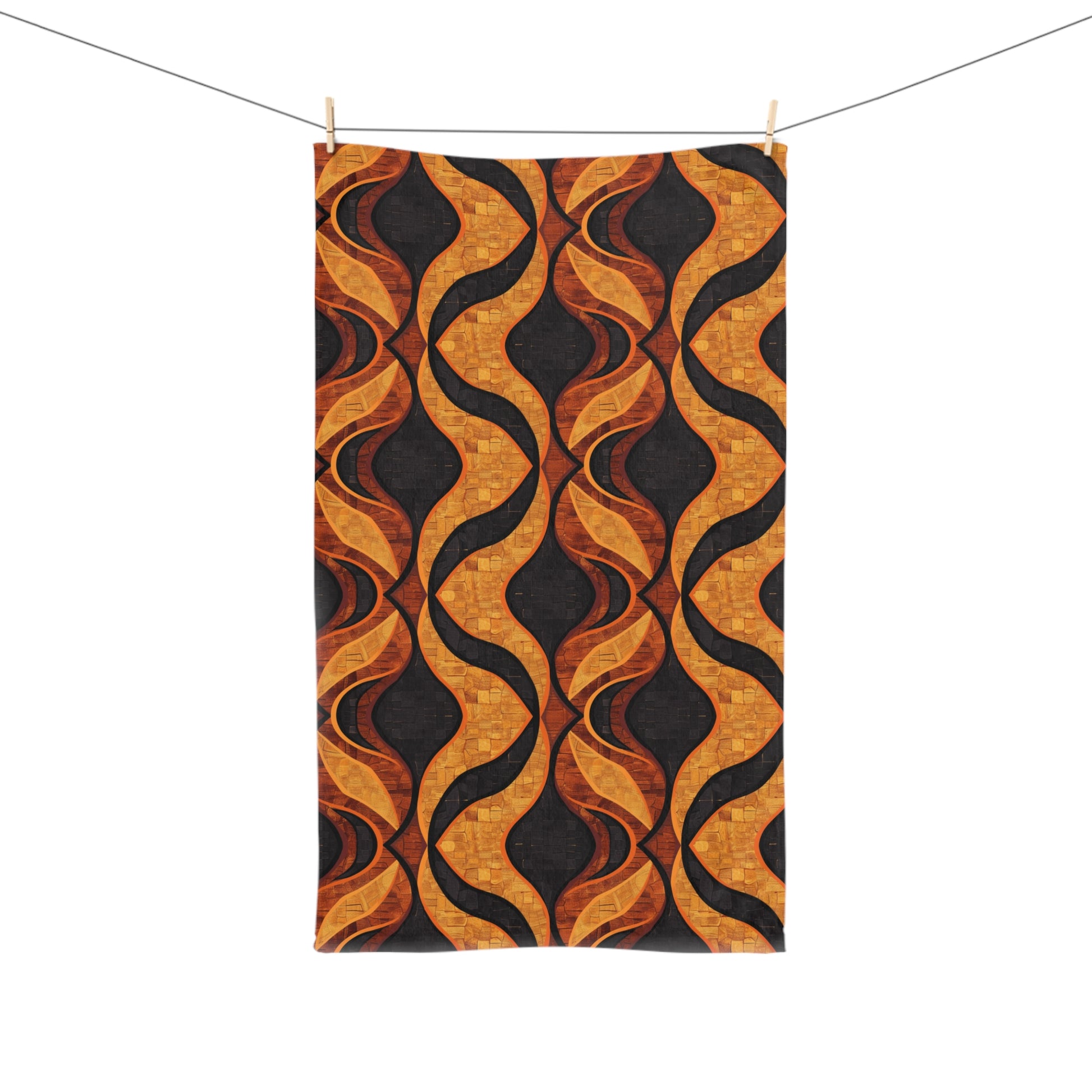 Decorative towel with gold and black wavy pattern hanging on a line.