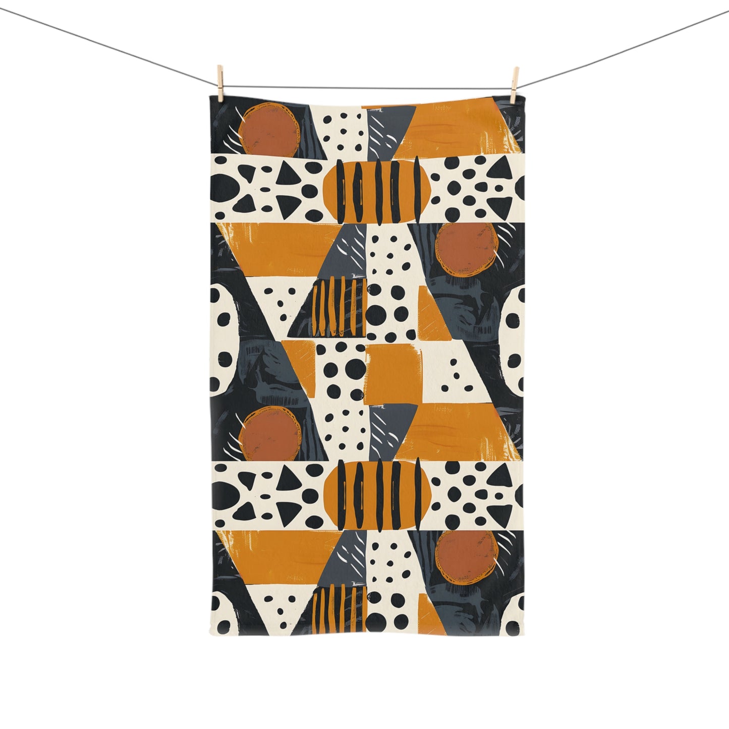 Geometric patterned towel with orange, black, and white design on a white background