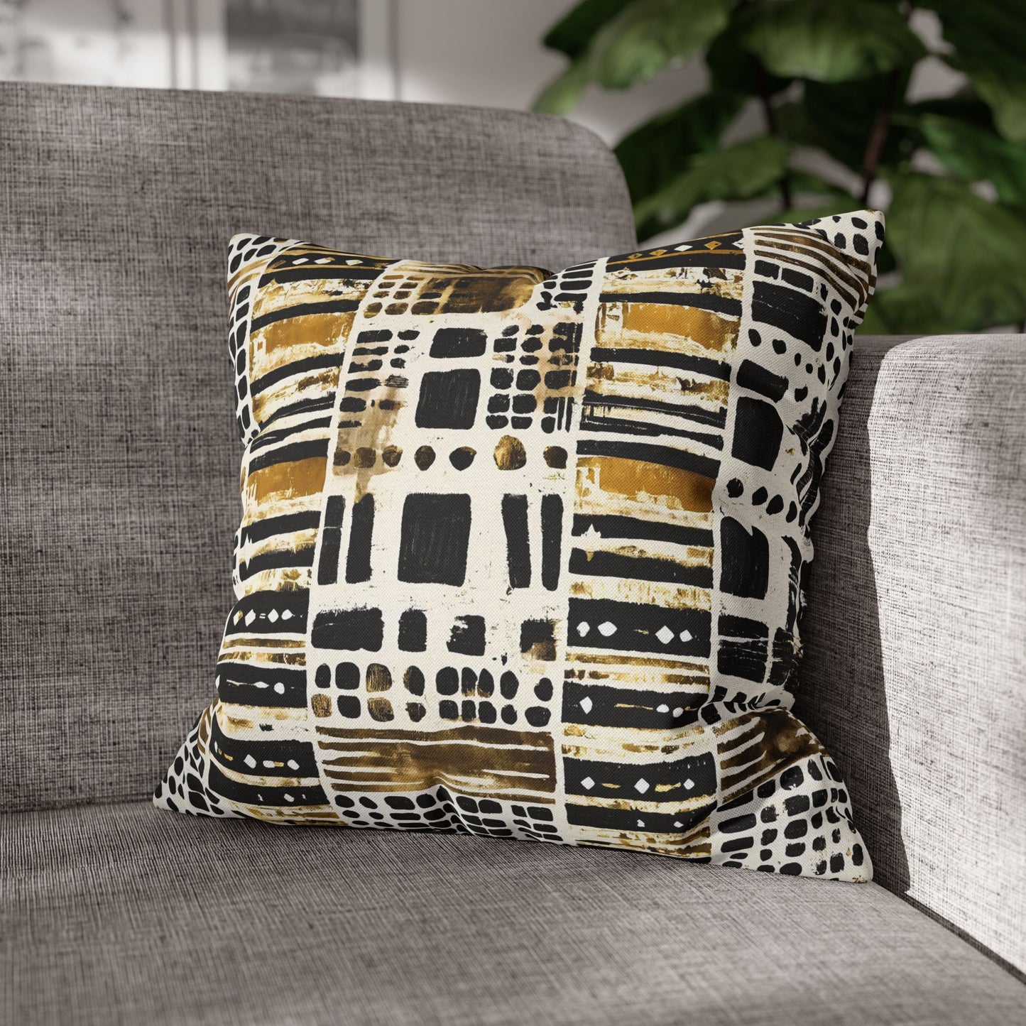 Mudcloth Print pillow on a gray sofa with a blurred plant in the background