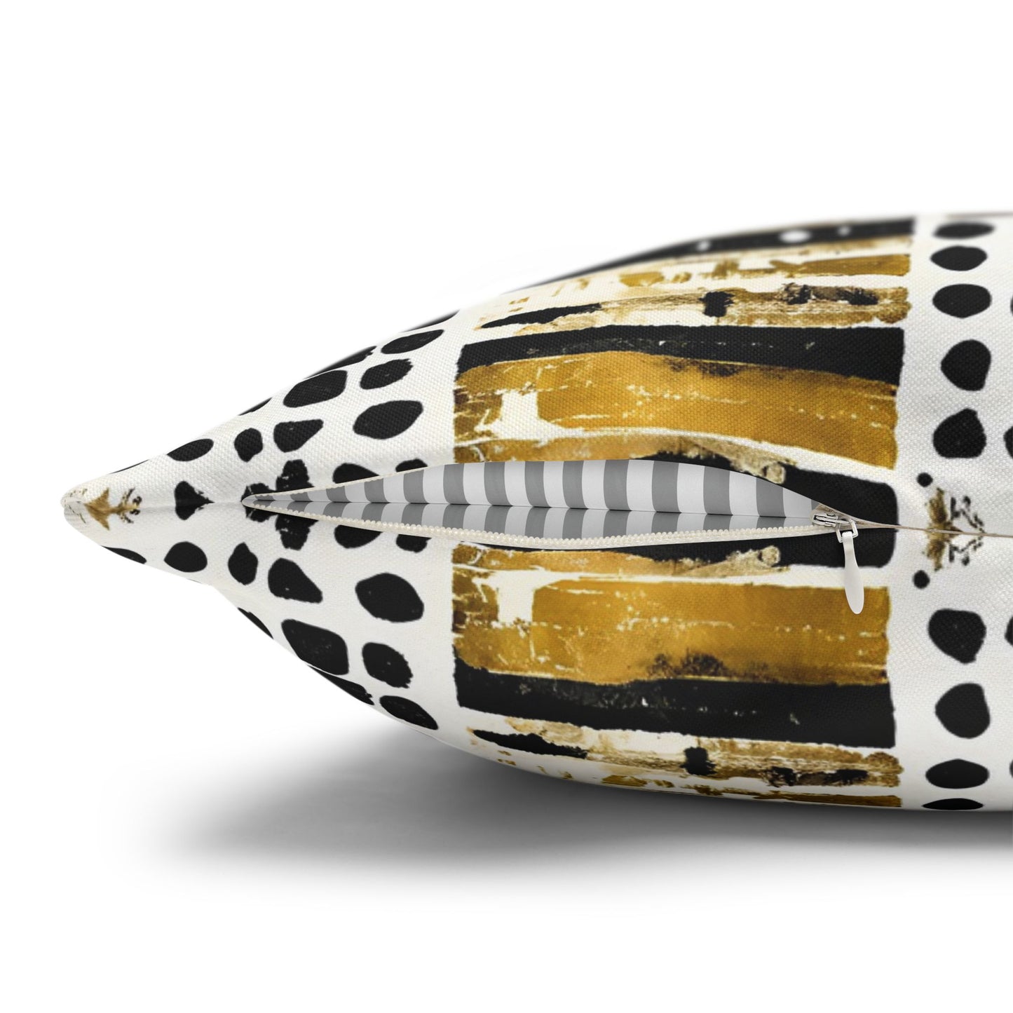 Decorative pillow with abstract black, white, and gold pattern on a white background