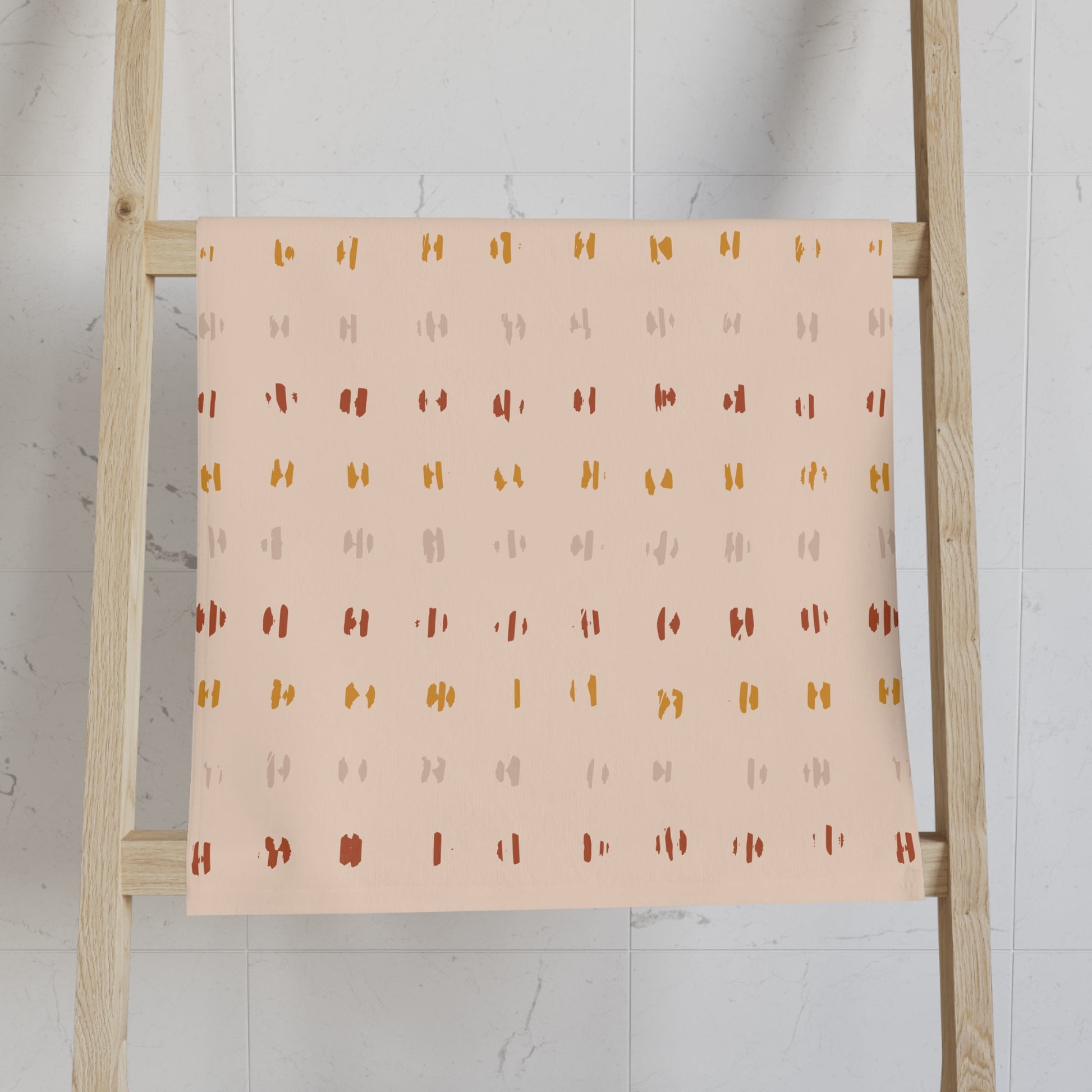 Patterned towel on a wooden ladder against a white wall