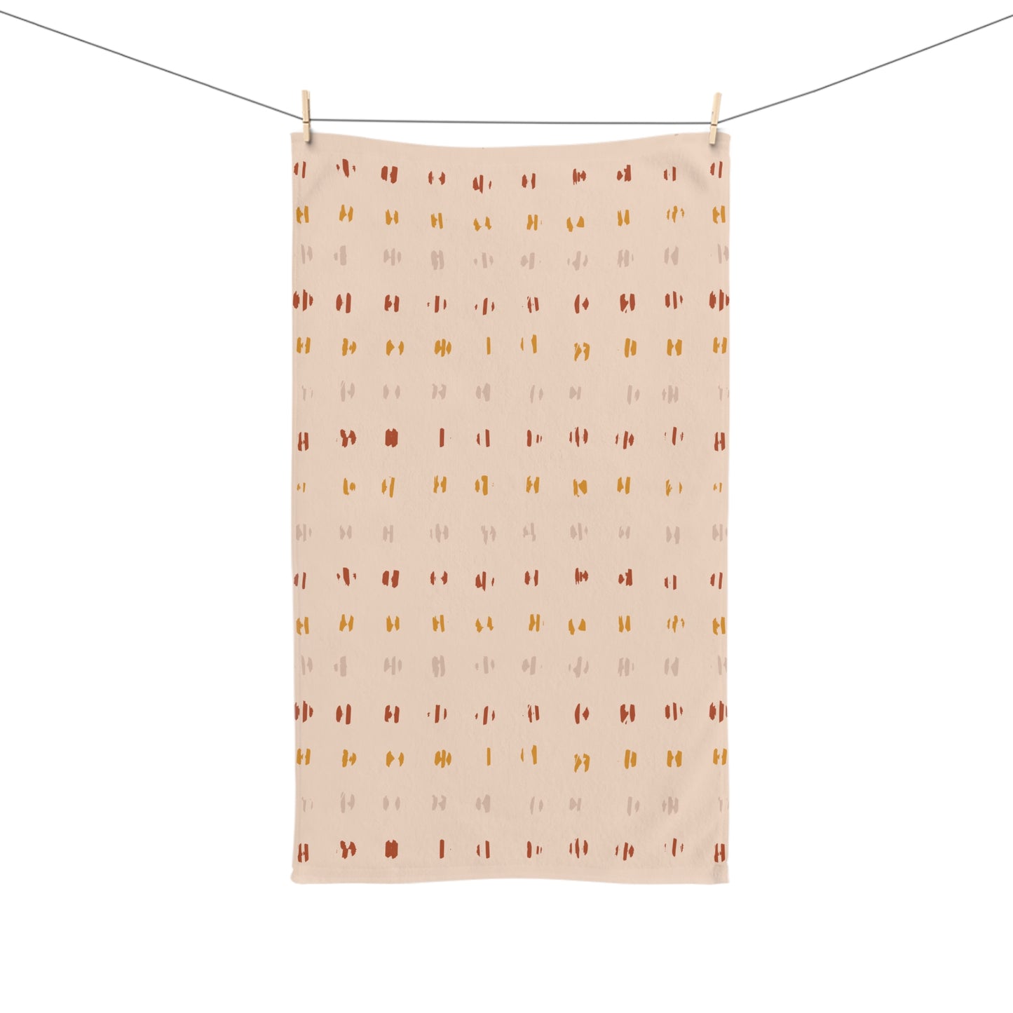 Patterned towel hanging on a line against a white background