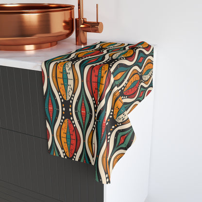 Colorful patterned towel hanging on a towel rack with a copper faucet in the background.