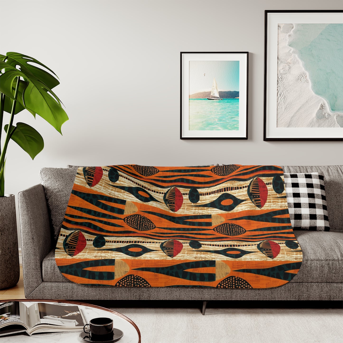 Colorful African art patterned blanket on a sofa with a plant and framed pictures in the background.