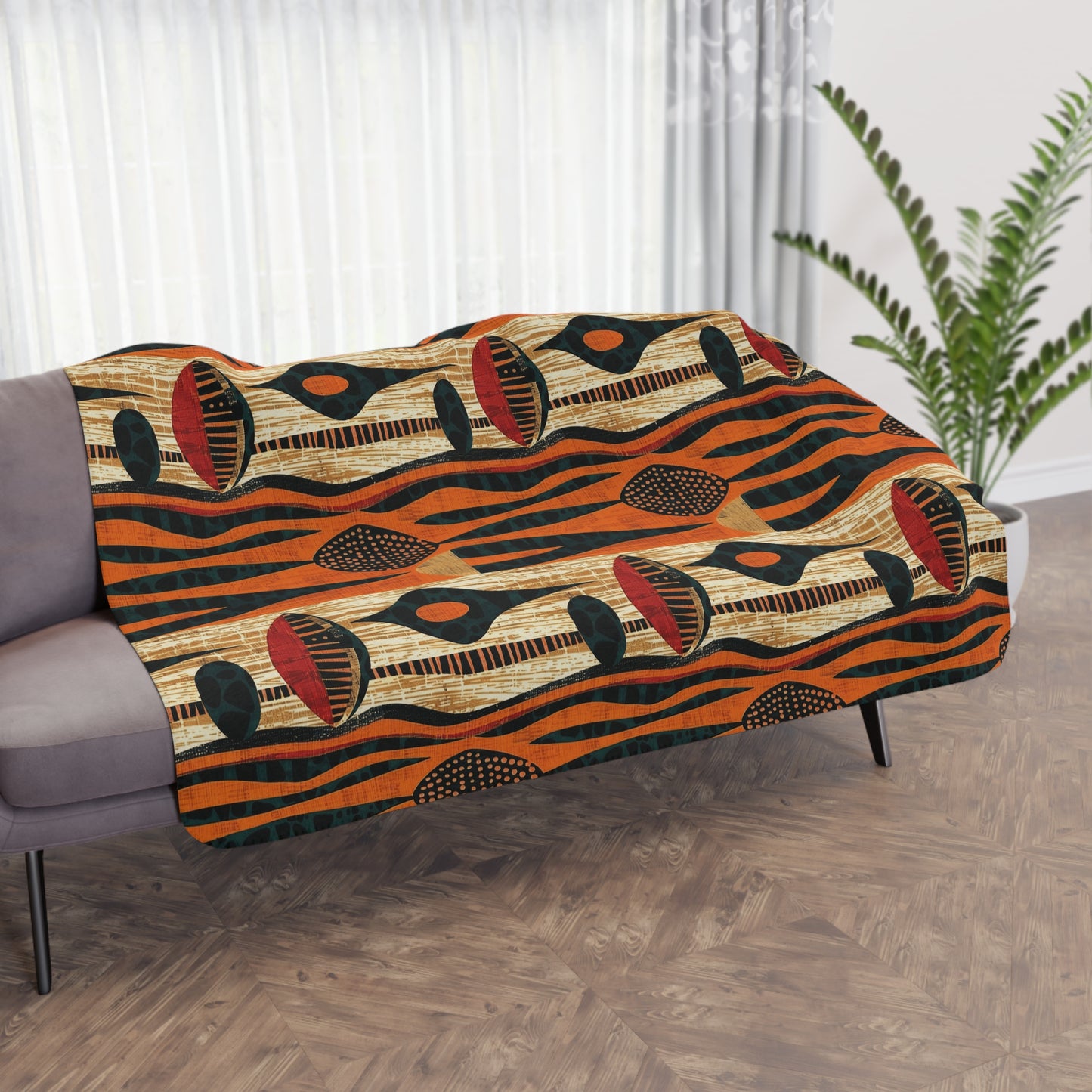 Decorative blanket with a geometric pattern draped over a sofa in a room with curtains and a plant.