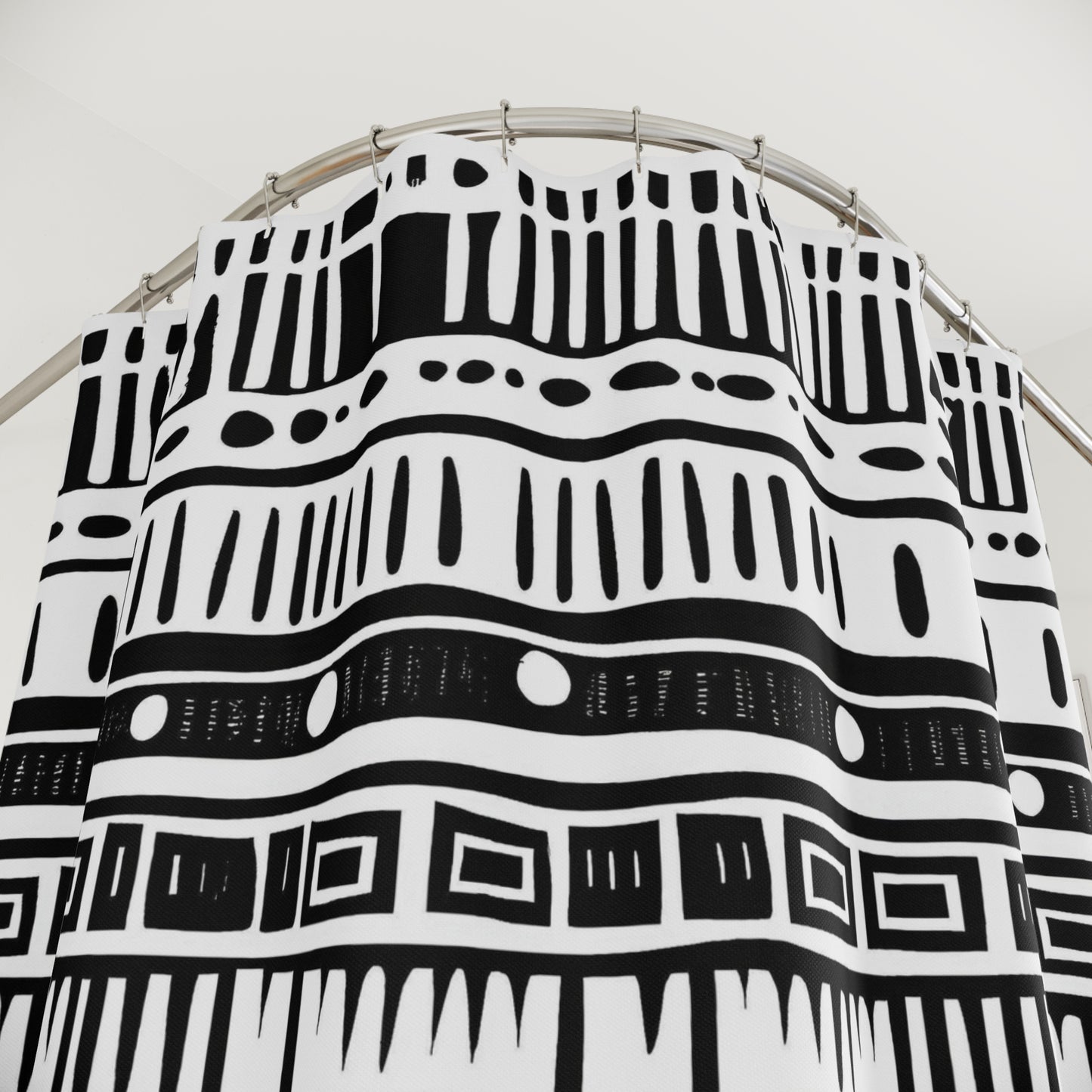 Black and white shower curtains on a circular stand against a white background