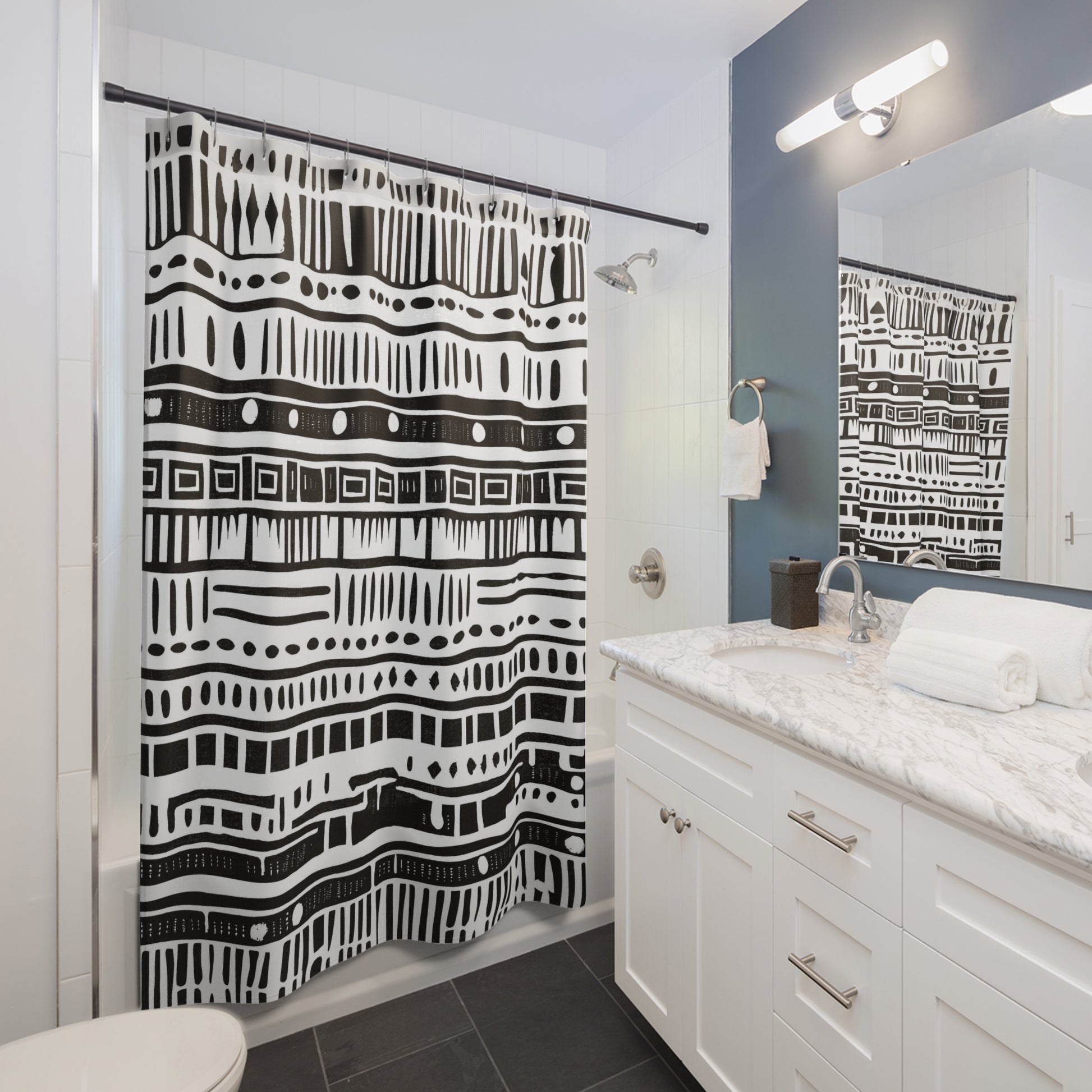 Bathroom with a black and white tribal shower curtain, white vanity, and mirror.