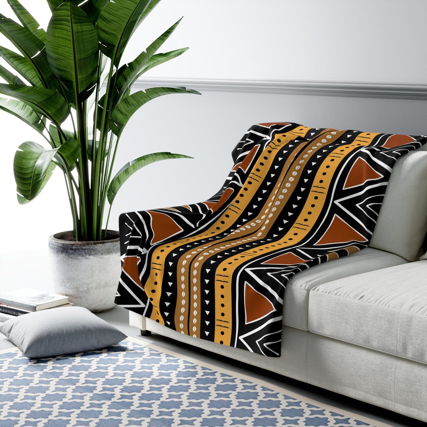 Decorative blanket with tribal pattern draped over a sofa in a living room setting.
