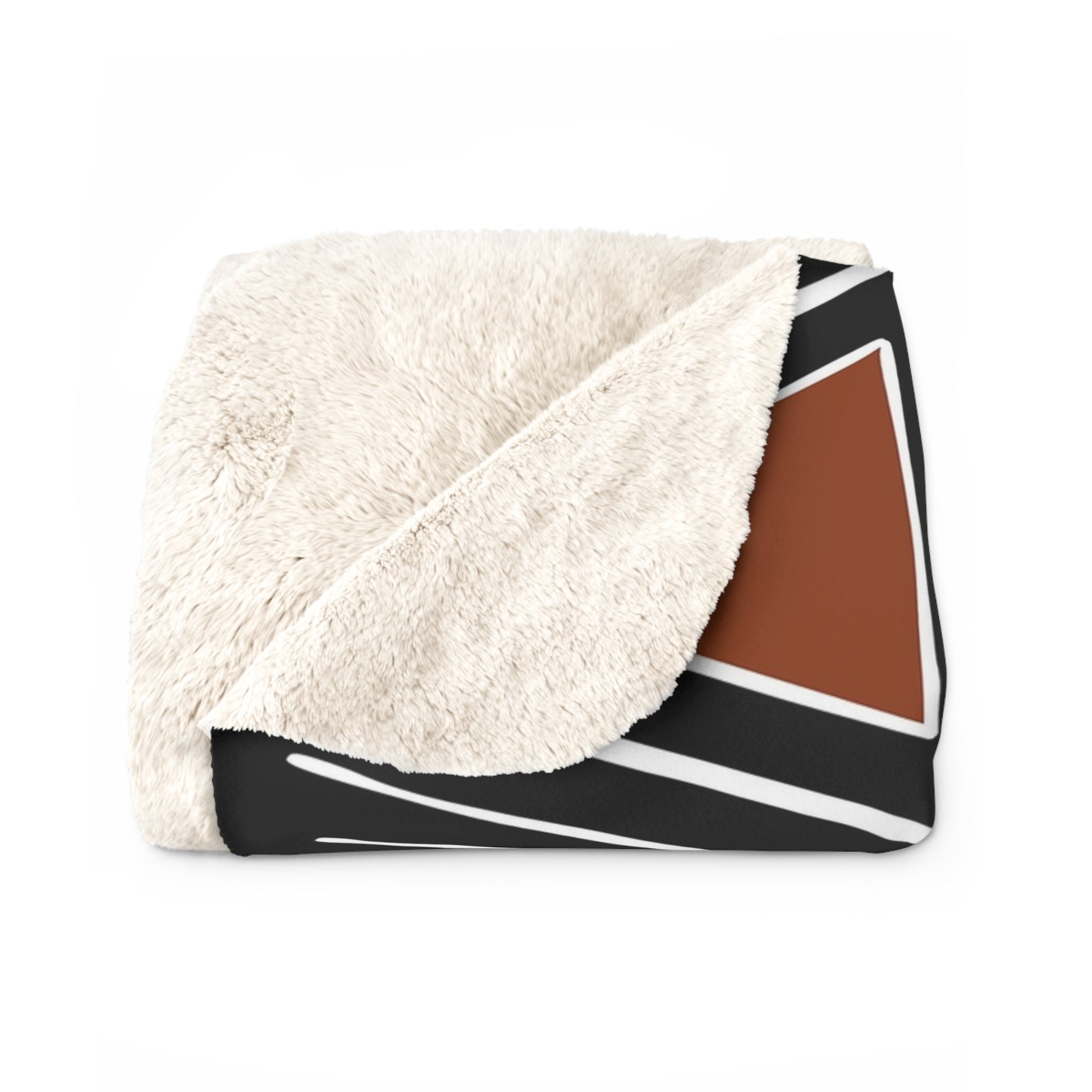 Folded blanket with white sherpa side and geometric pattern on a white background