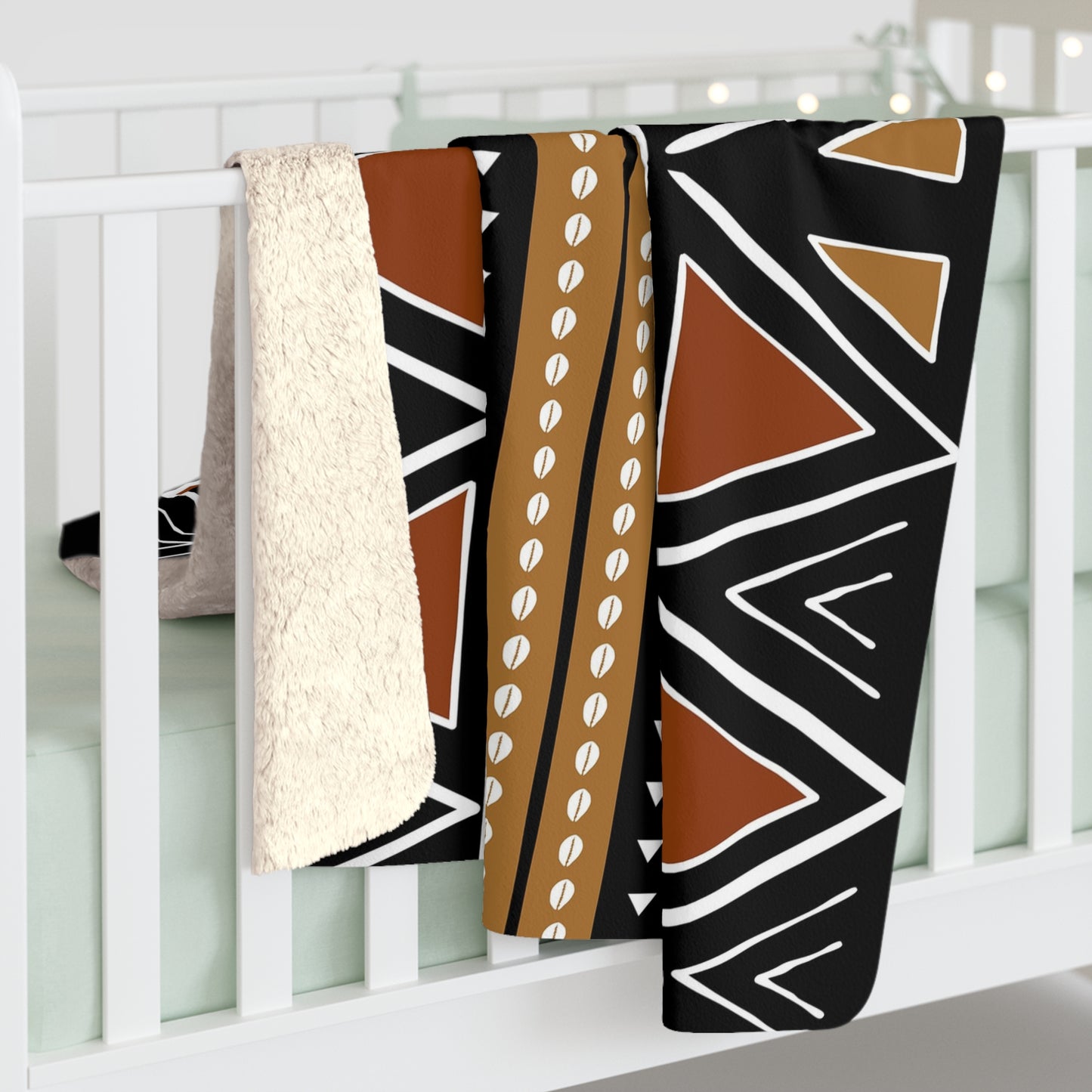 Three patterned blankets draped over a white crib.