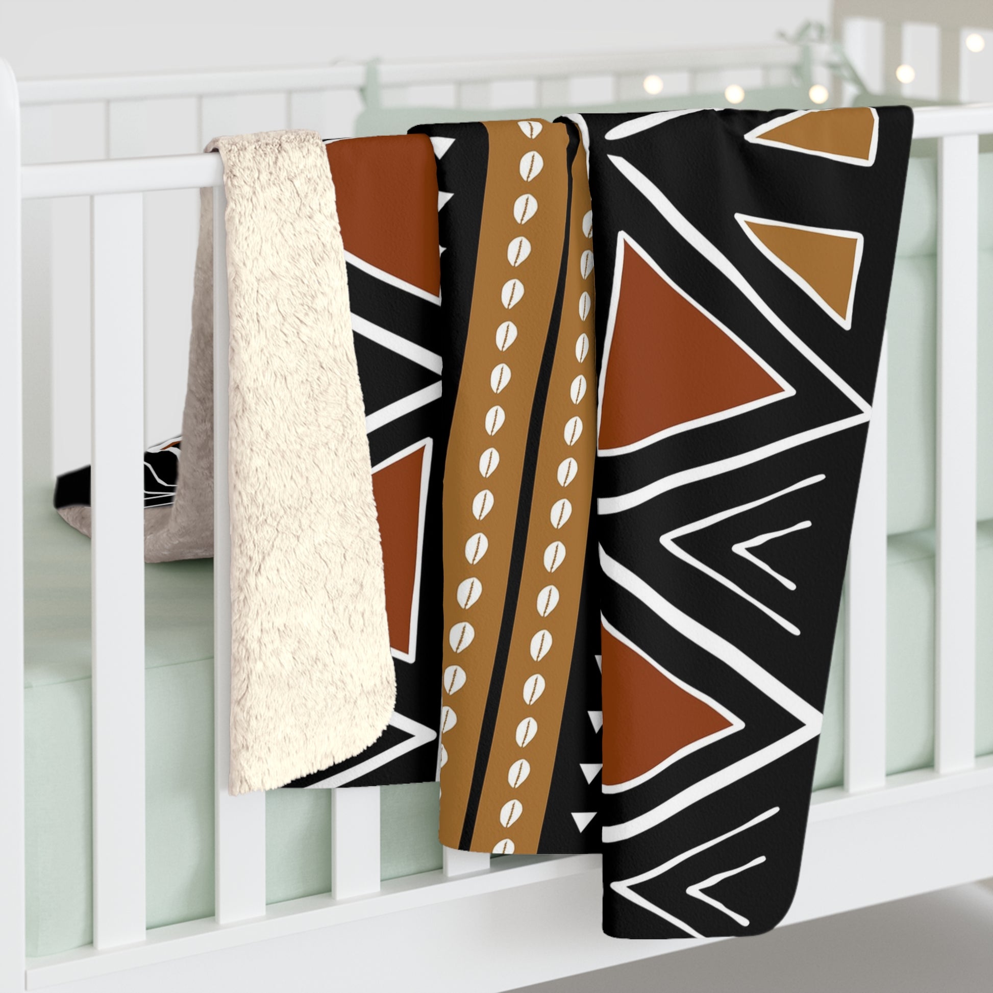 Three patterned blankets draped over a white crib.