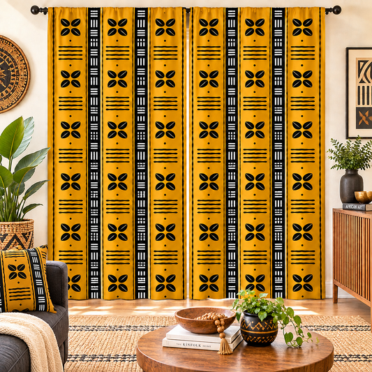 A pair of long window curtains hanging in a styled living room. The curtains feature a bold yellow and black vertical pattern with geometric and floral motifs.