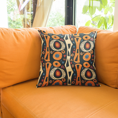 A multicolored geometric patterned African tribal throw pillow cover on an orange sofa.