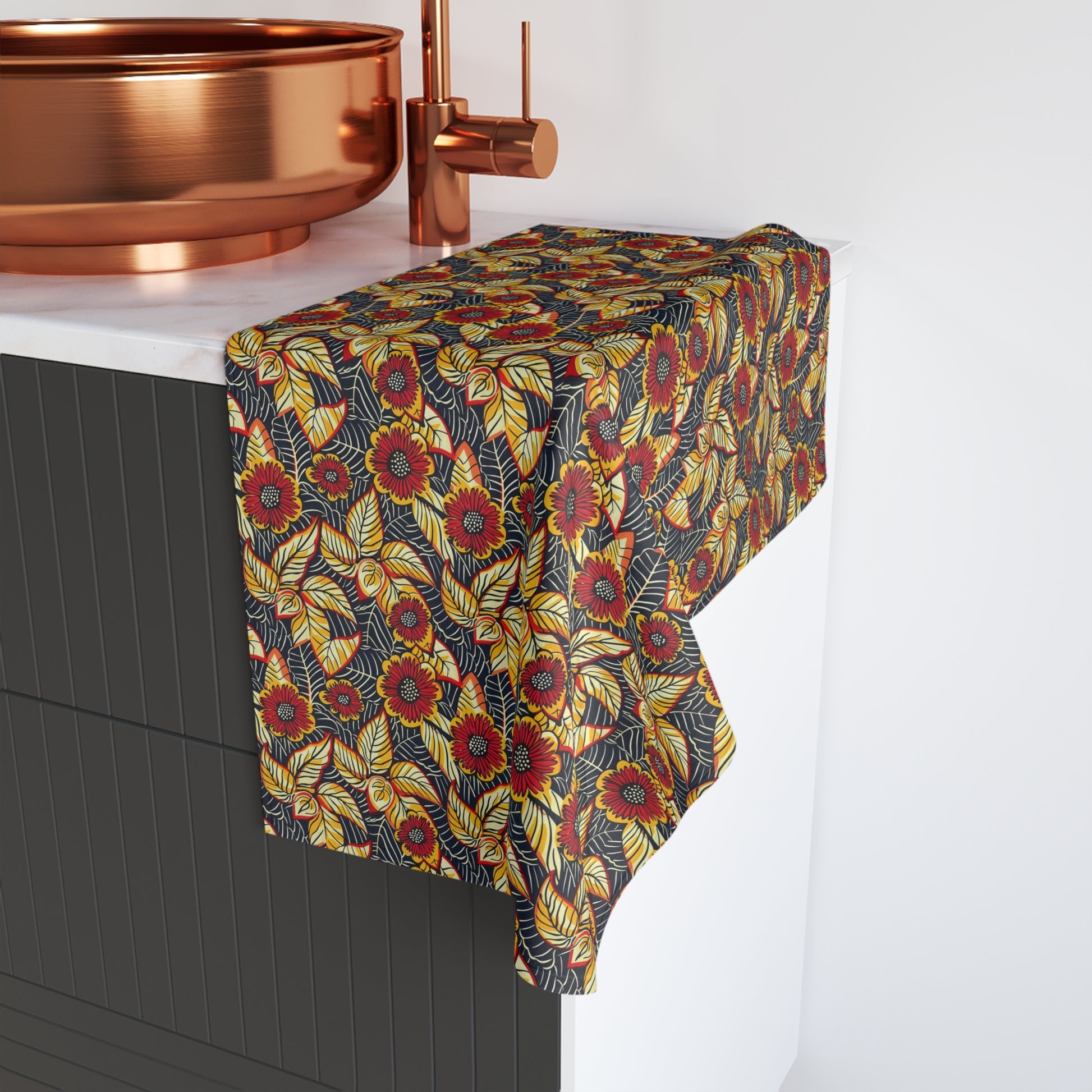 Floral patterned towel draped over a bathtub with copper fixtures.