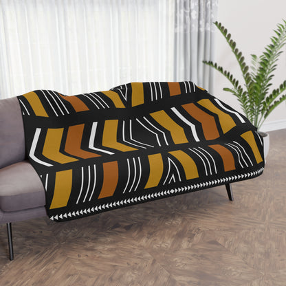 Patterned throw blanket draped over a sofa in a living room setting.