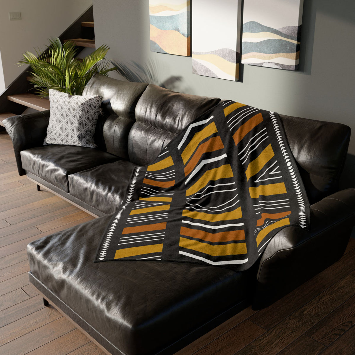 Striped blanket draped over a brown leather sofa in a living room setting.