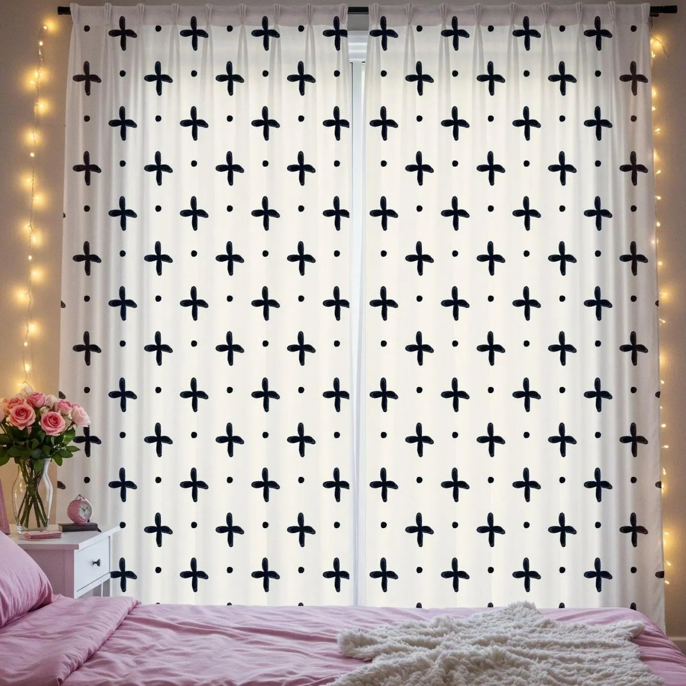 Curtains with black cross pattern in a bedroom setting with fairy lights and flowers.
