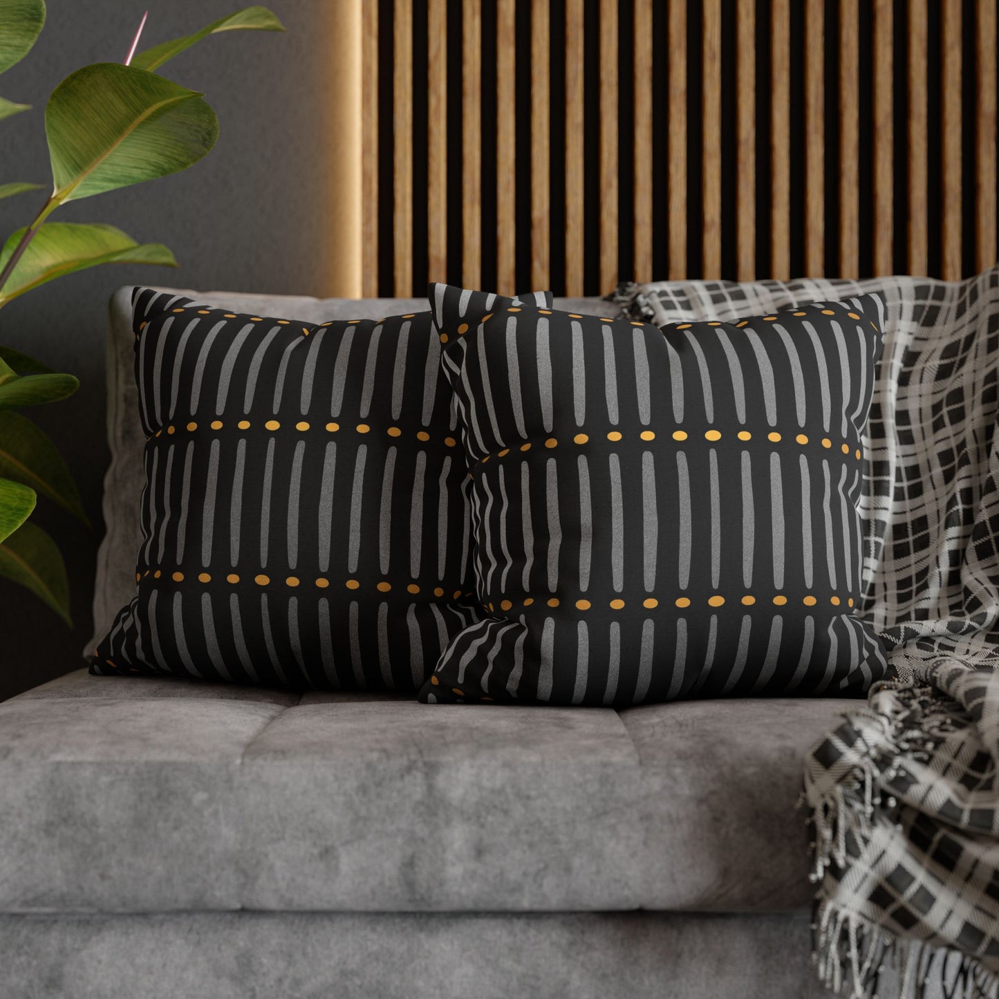 Decorative pillows with black and white patterns on a gray sofa.