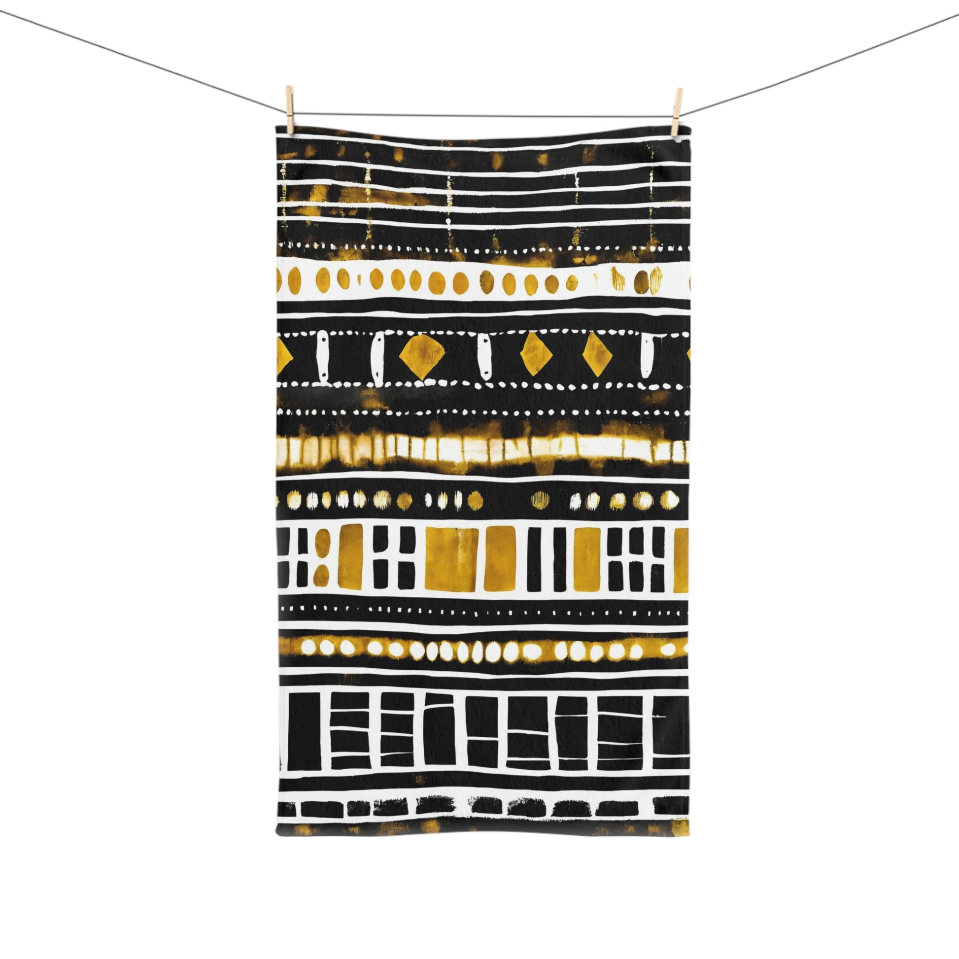 Mudcloth  towels with black, gold, and white design hanging on a line.
