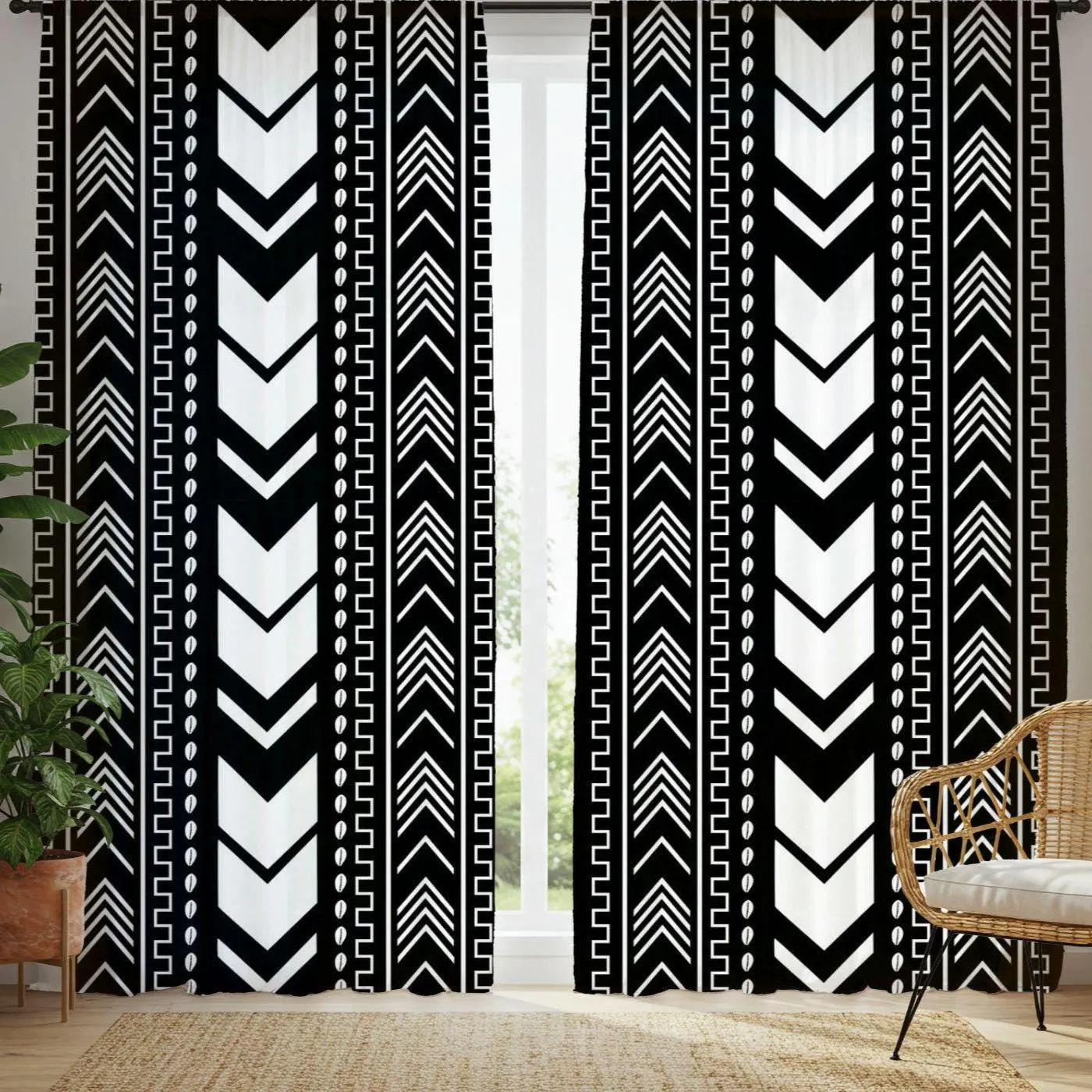 Black and white patterned curtains in a room with a chair and plant.