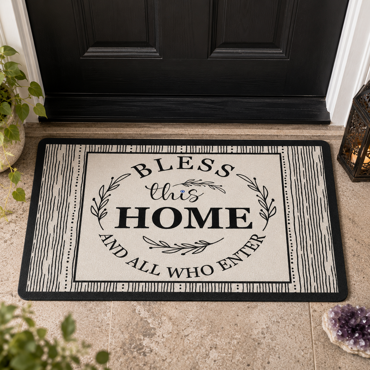 Doormat with 'Bless this Home and All Who Enter' text on a black and white design, placed in front of a black door.