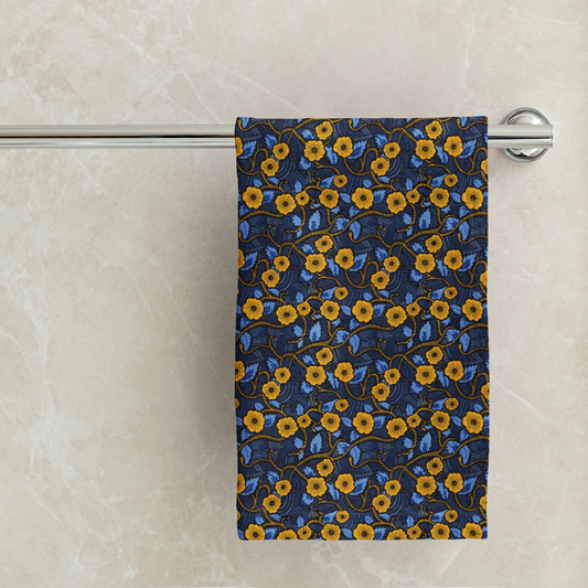 Floral-patterned towel hanging on a rack against a marble wall.