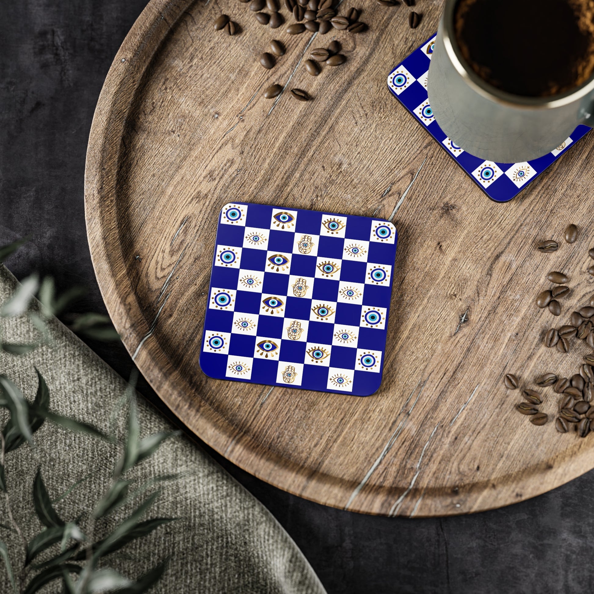 Blue and white patterned coaster on a wooden tray with coffee and seeds.