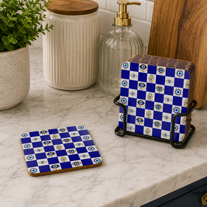 Blue and white checkered coasters on a kitchen counter with a plant and jars in the background.