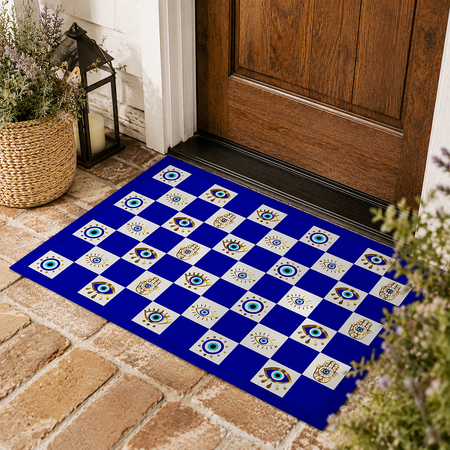 A rectangular blue and white checkered doormat with evil eye tile patterns, placed on a brick porch in front of a wooden door.