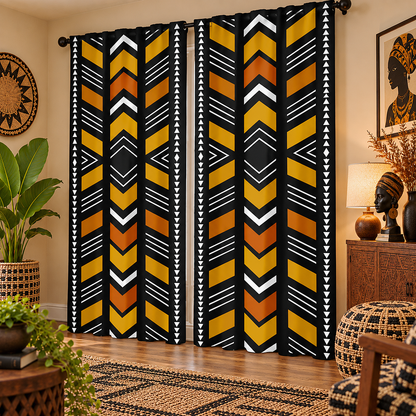 A pair of black curtains with a bold geometric pattern in yellow, orange, and white, hanging in a styled living room setting.