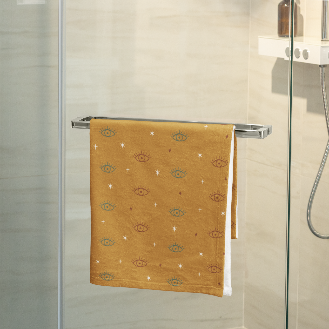 Towel hanging on a rack in a bathroom with a sink and decorative elements.