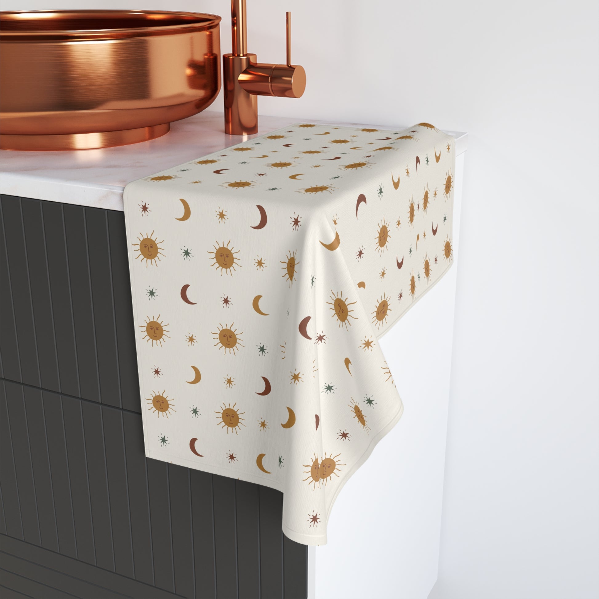 Hand Towel with celestial pattern on a kitchen counter with copper fixtures.