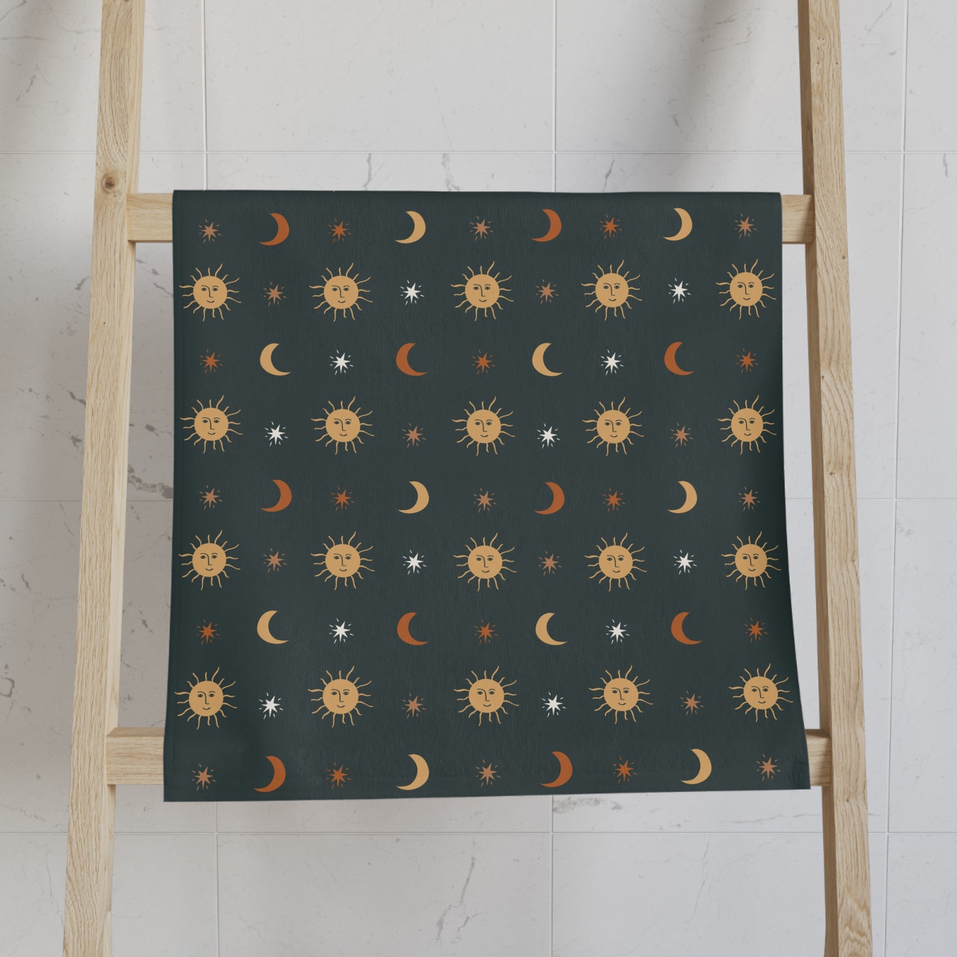 celestial hand towel with sun and moon pattern on a wooden ladder against a white wall