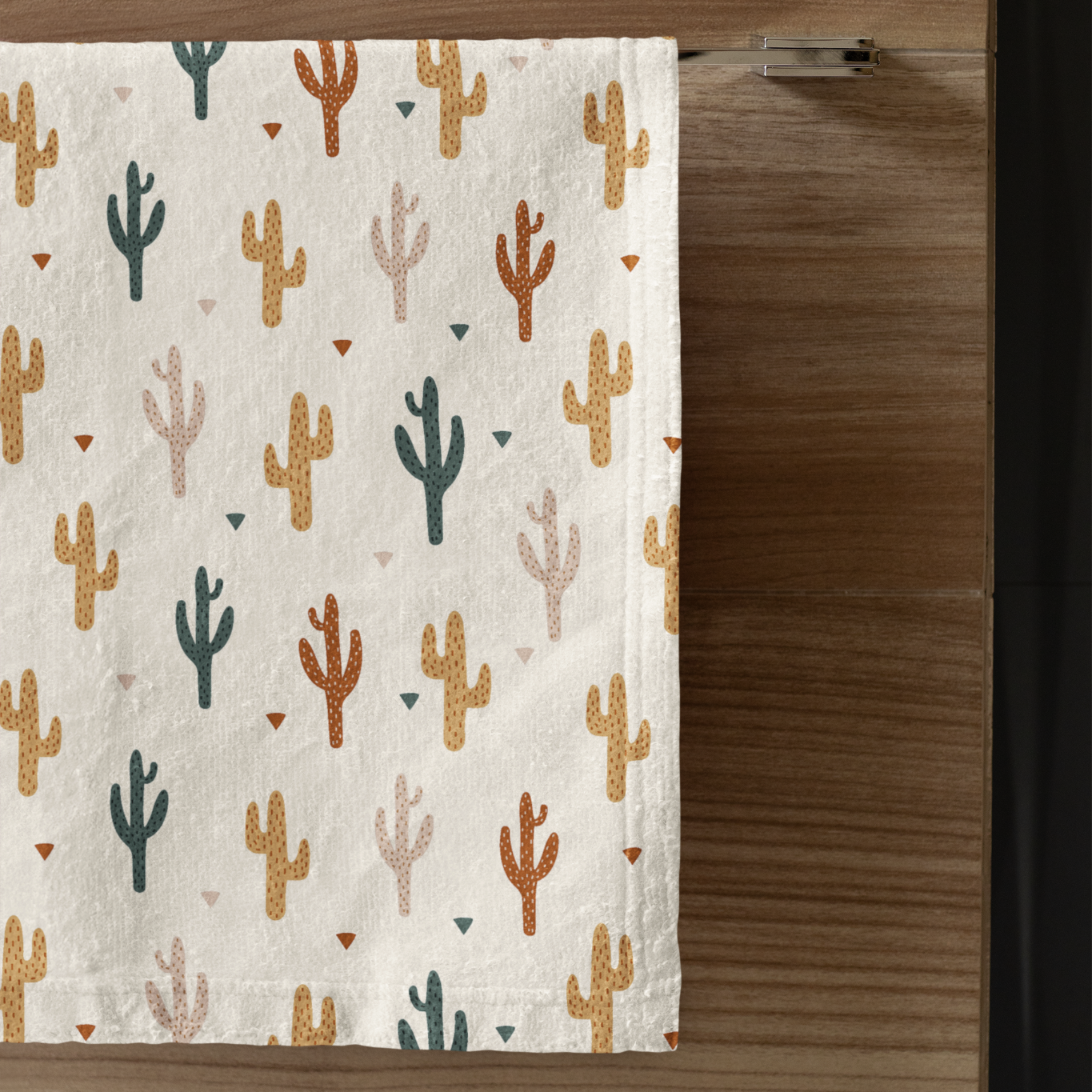 Towel with cactus pattern hanging on a wooden rack