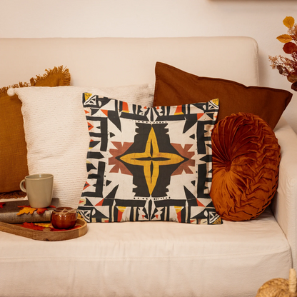 Geometric throw pillow on cream couch with fall decor and autumn leaves