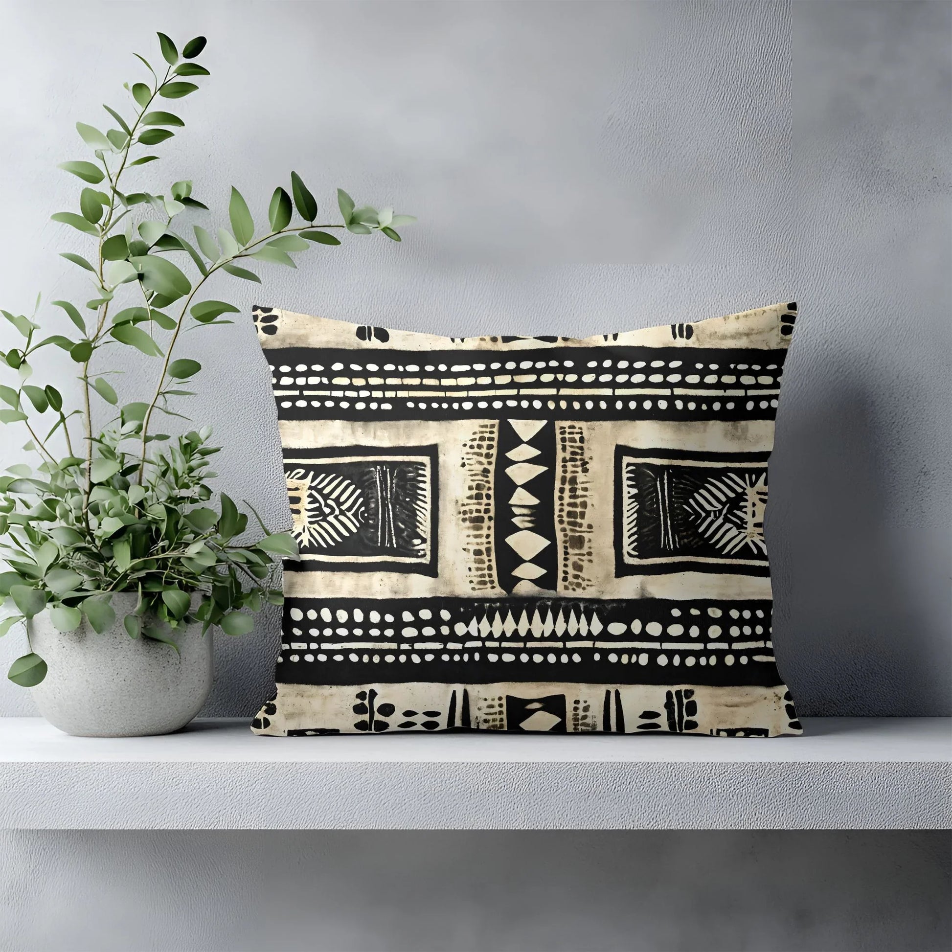 Tribal print throw pillow on minimalist shelf beside potted plant, modern home decor