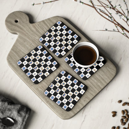 Set of four coasters with a evil eye design on a wooden cutting board with a cup of coffee.