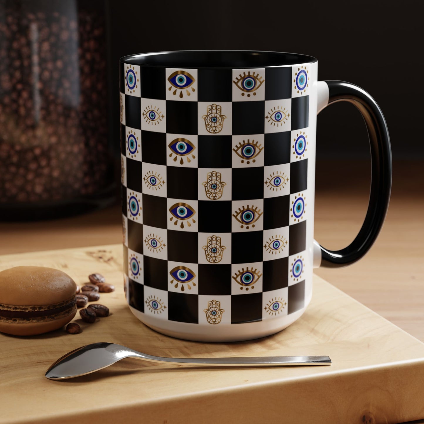 Checkered mug with eye pattern on a wooden surface with coffee beans and a macaron.