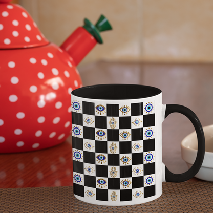Mug with black and white pattern on a kitchen counter with a red polka dot teapot.