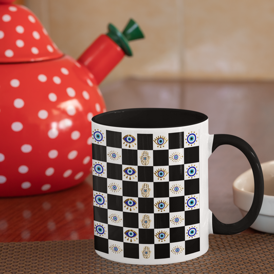 Mug with black and white pattern on a kitchen counter with a red polka dot teapot.