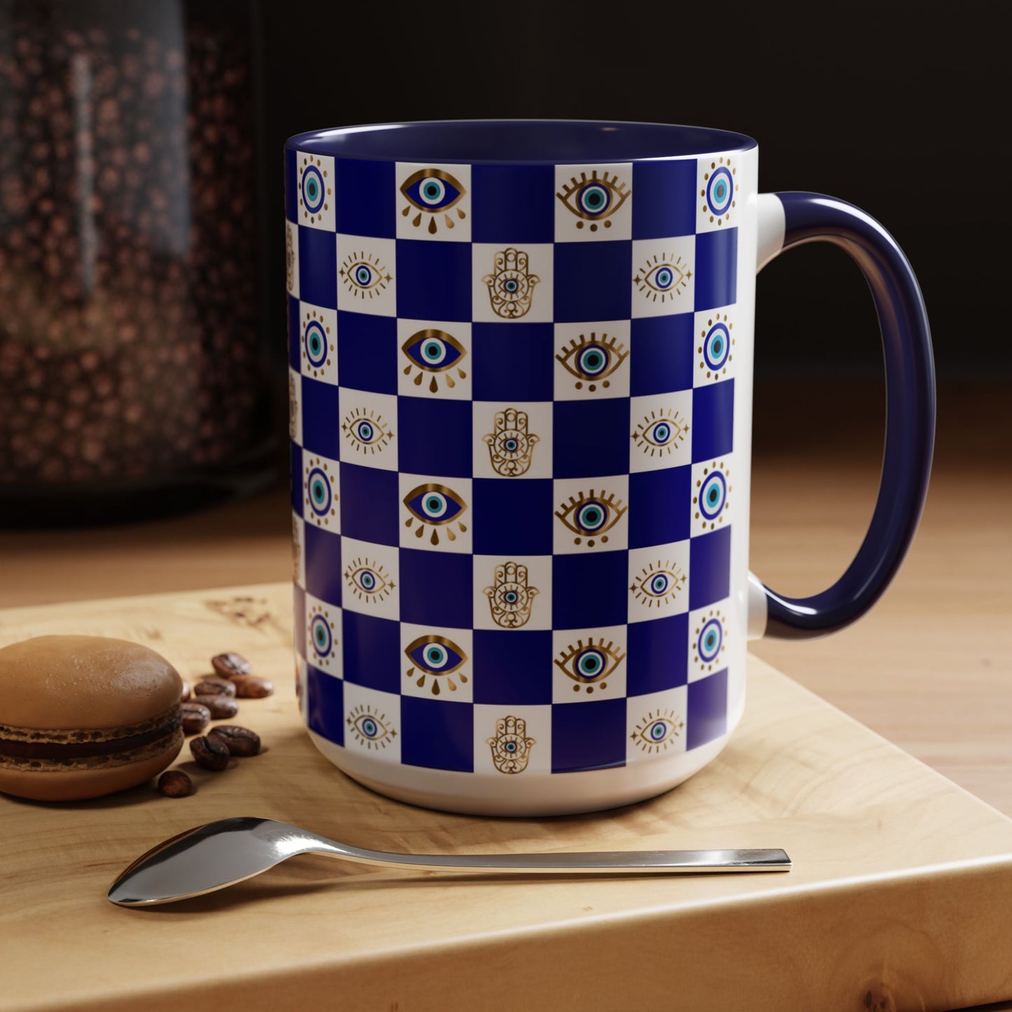 Blue and white checkered mug with decorative patterns on a wooden surface with coffee beans and a macaron.