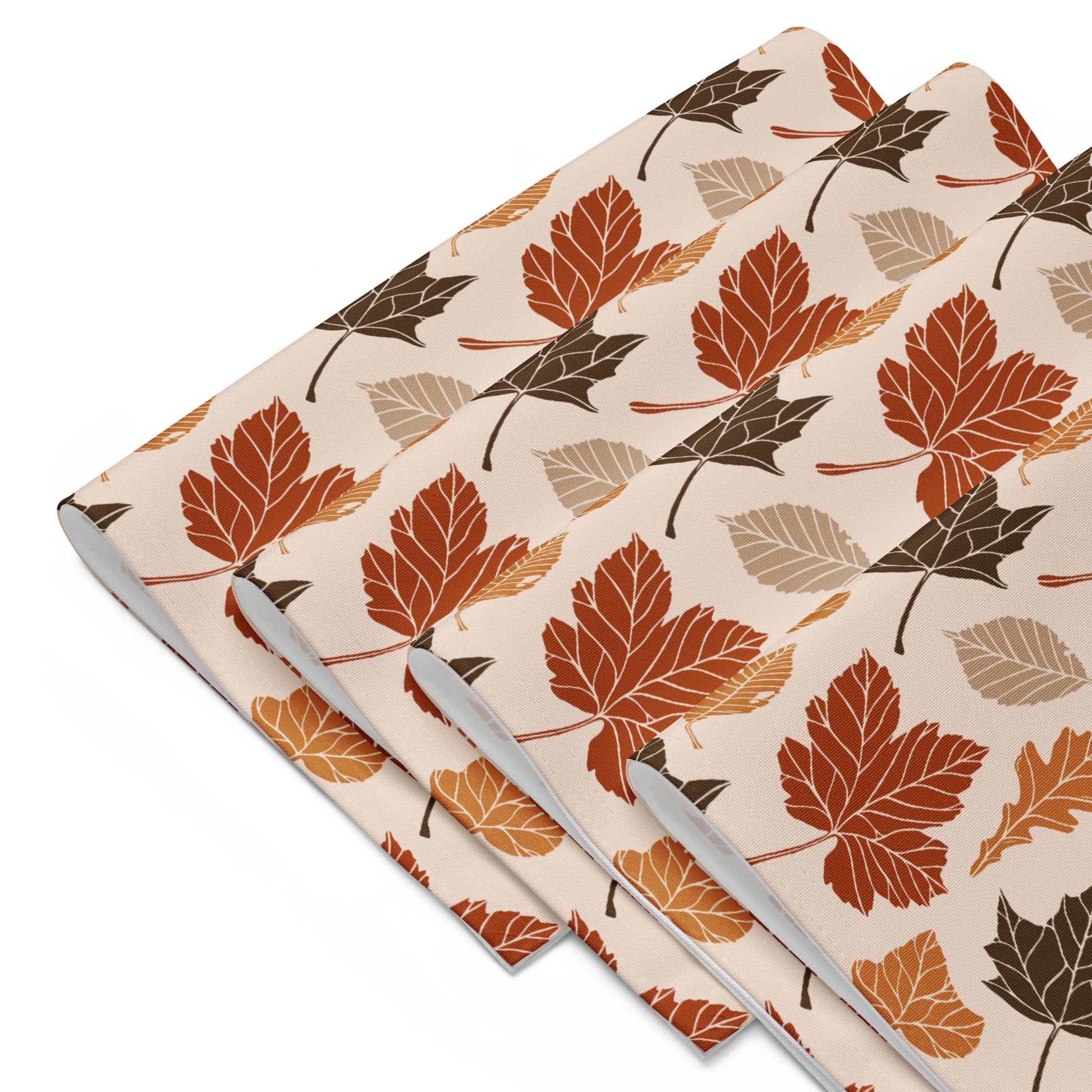 Two folded fabric swatches with a leaf pattern on a beige background