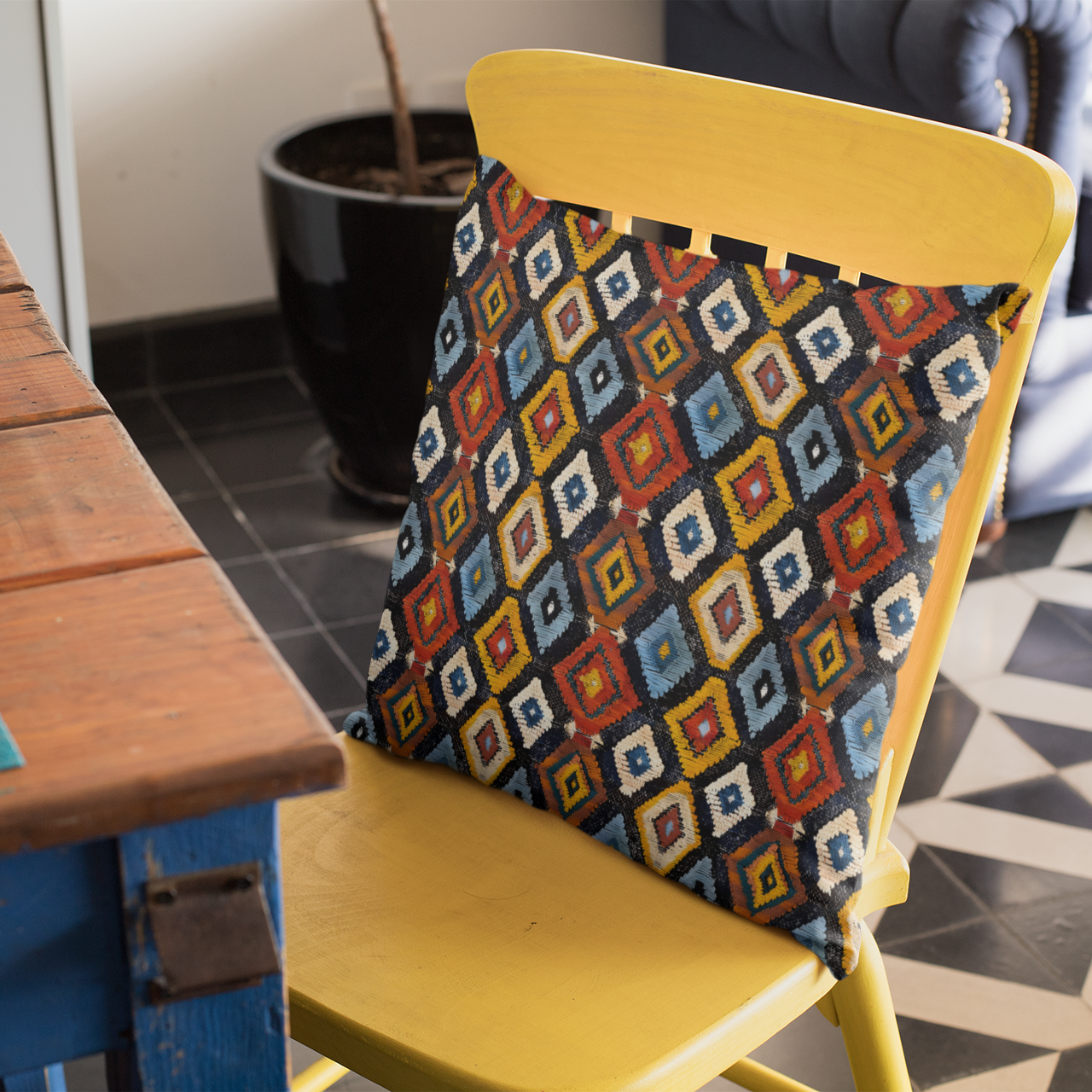 Yellow chair with a colorful geometric Berber patterned cushion on a checkered floor.