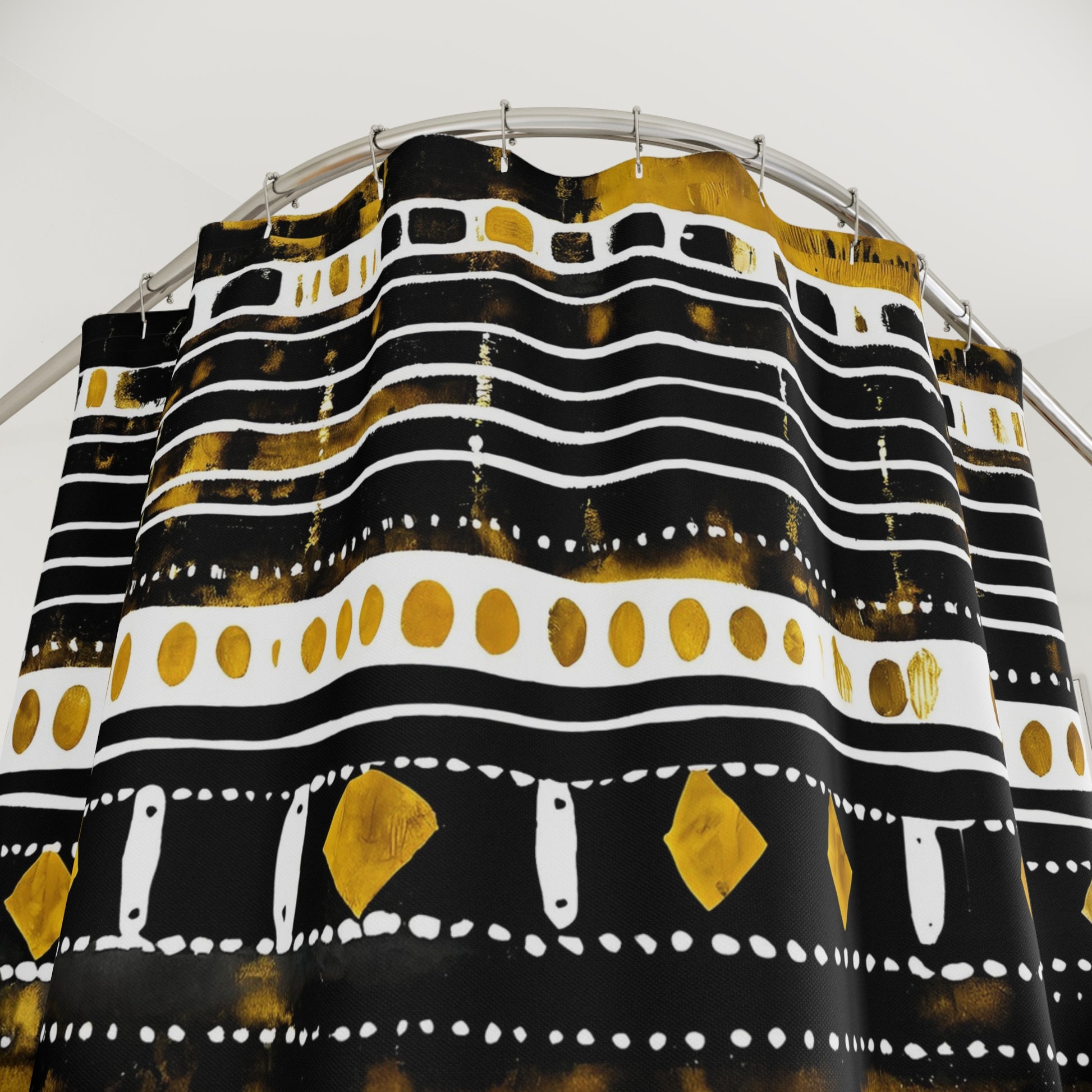 Black, gold, and white patterned shower curtain on a rod against a white background