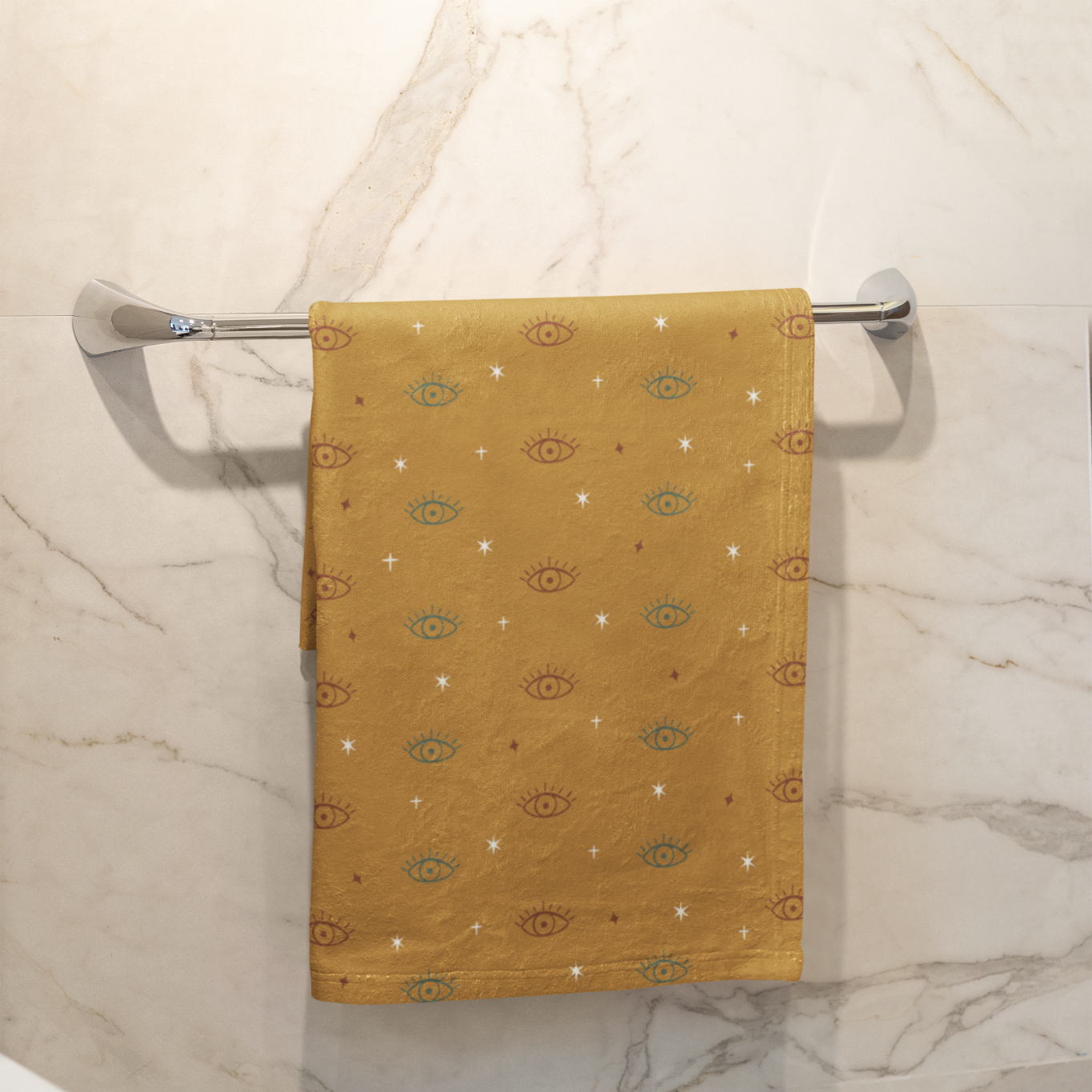 Yellow patterned towel hanging on a towel rack against a marble wall.