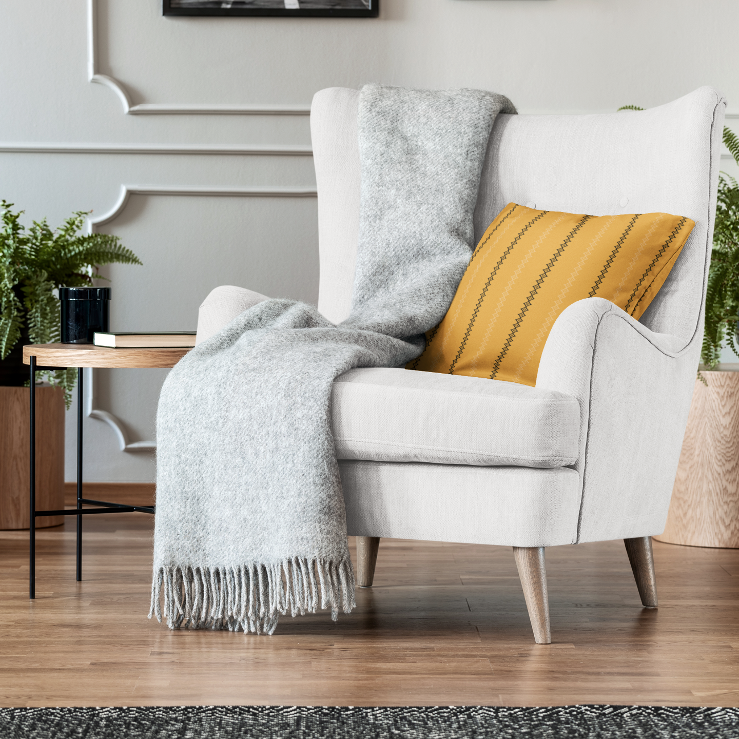 White armchair with a yellow pillow and gray blanket in a living room setting.